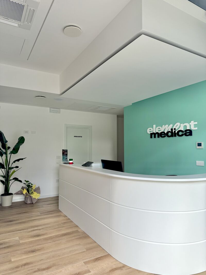 La reception del Poliambulatorio Element Medica con il logo sulla parete verde